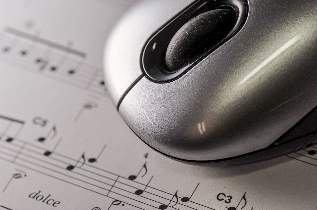 Computer mouse resting on sheet music