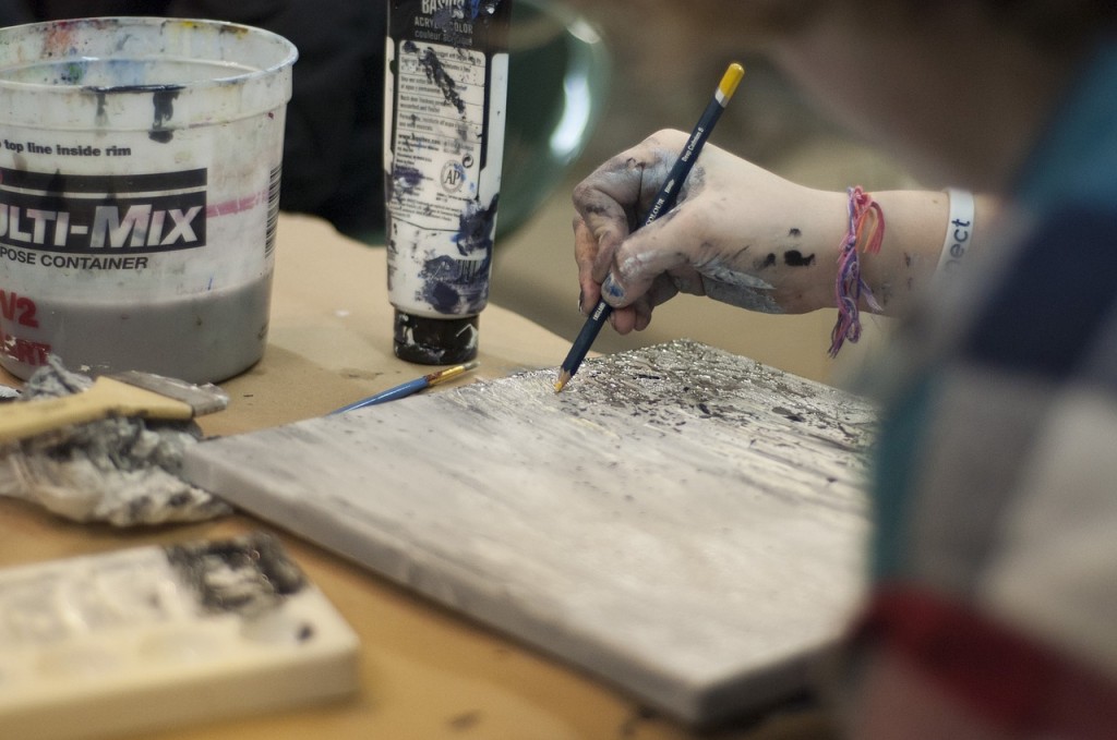 Hand of a painter working on canvas