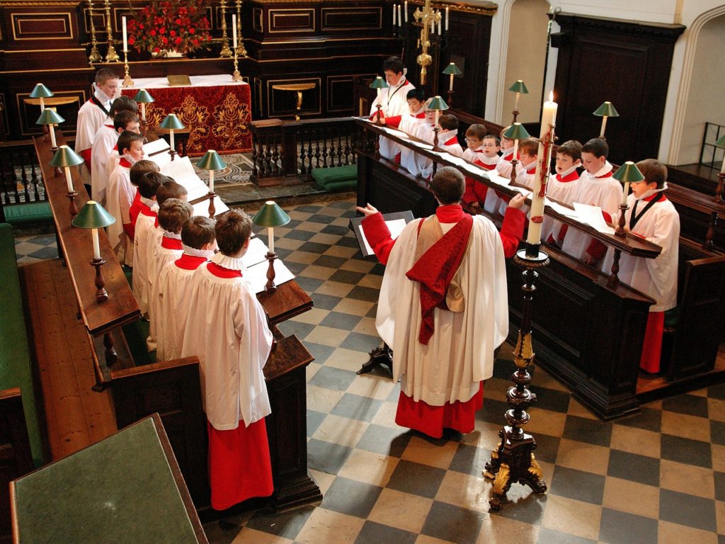 Choristers singing in cathedral choir stalls