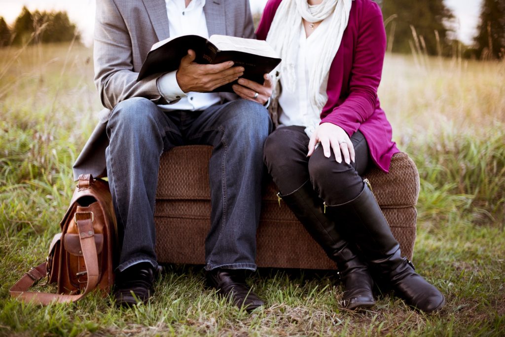 Man and woman reading a book, sitting together