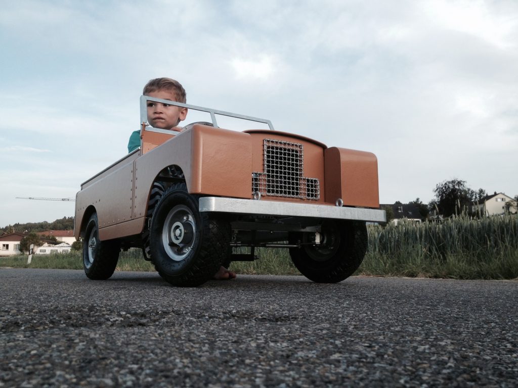 Boy driving a mini-landrover