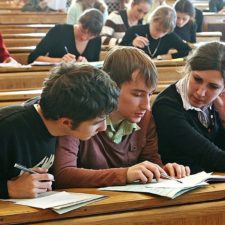 Students clustered around a book, working something out