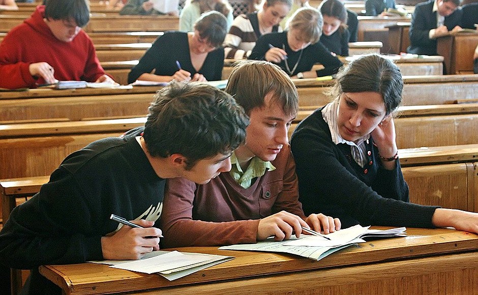 Students clustered around a book, working something out